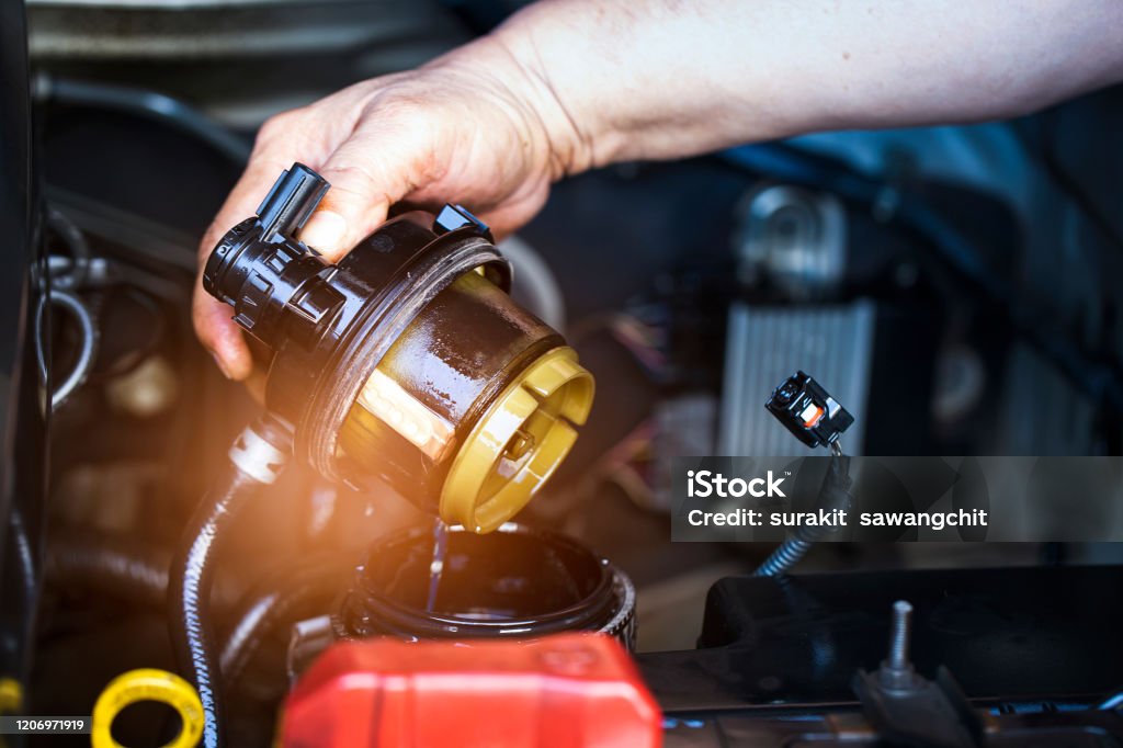 Car mechanic check the fuel filter at diesel engine. service or Preventive maintenance.
